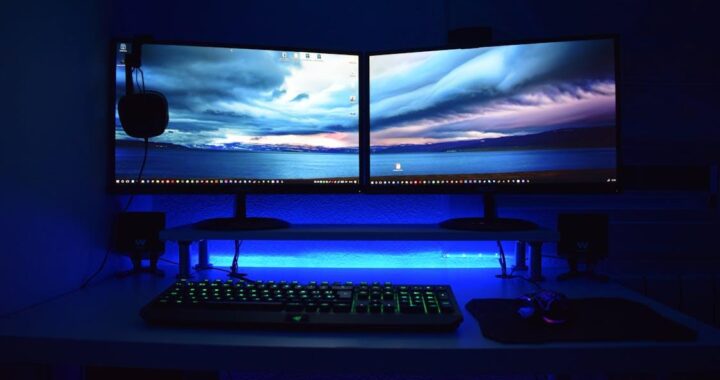 Free Dual monitors with blue lighting on a gaming desk setup. Stock Photo